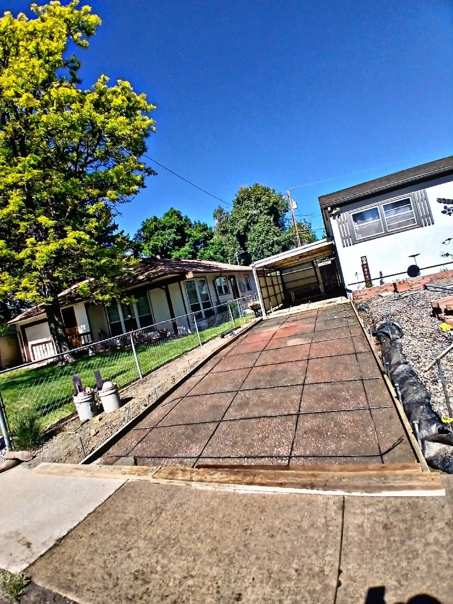 A driveway mid-replacement, with steel reinforcing mesh laid across the prepared base and timber forms at the apron.