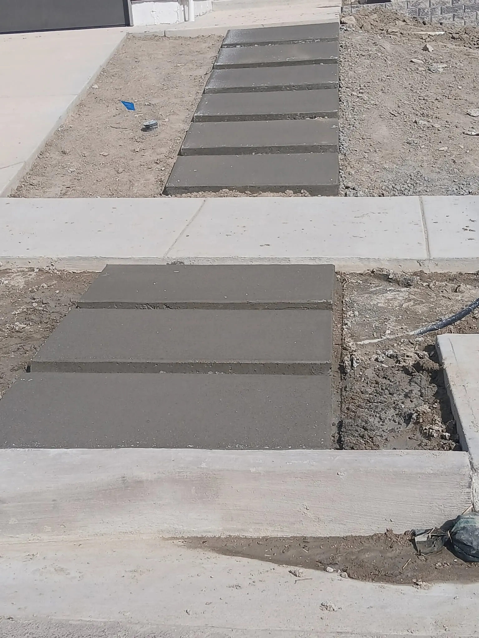 The same entry finished — poured concrete steps and landing running from the sidewalk up to the front door.
